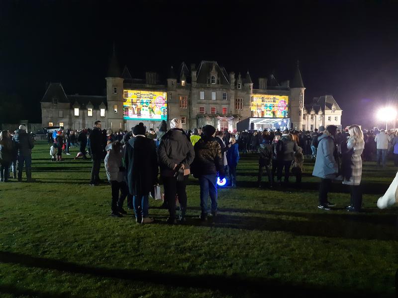 Calendar house with lots of people standing around.