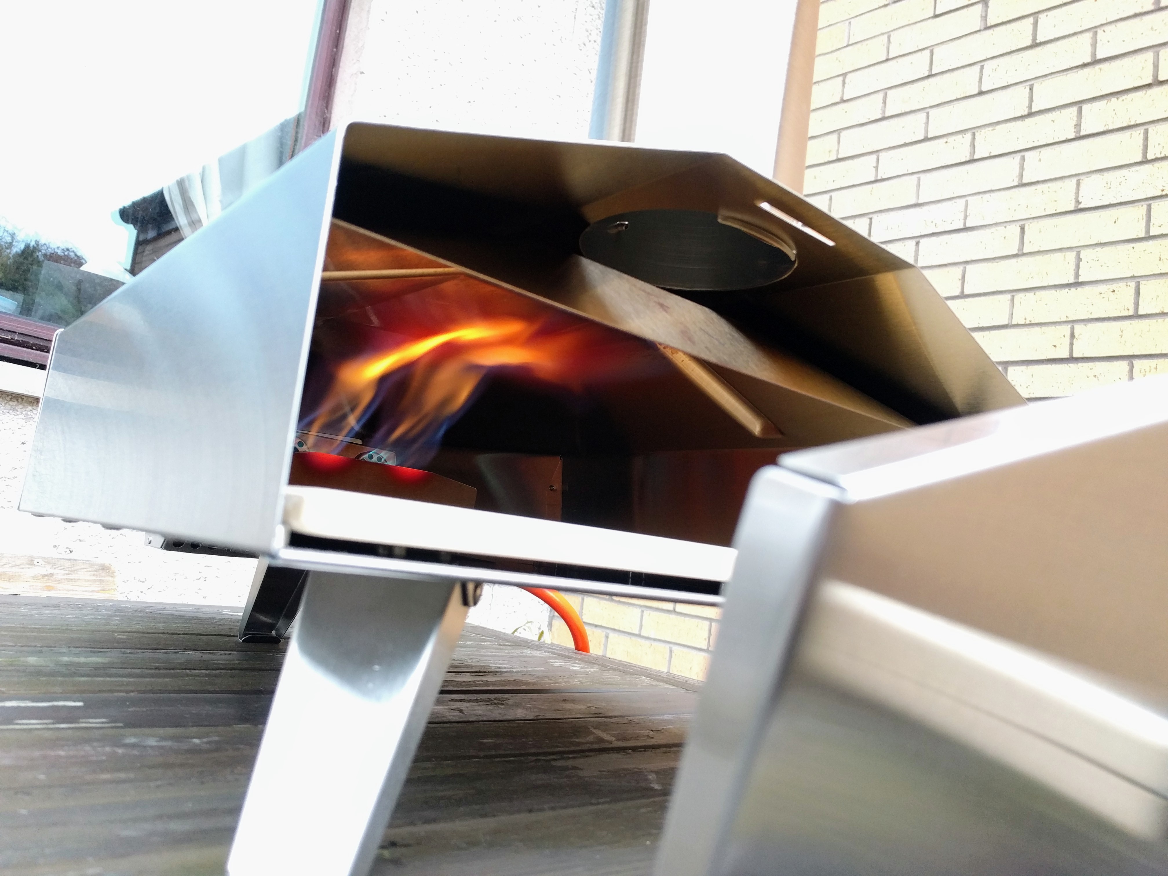 Pizza oven with door off showing internal flames