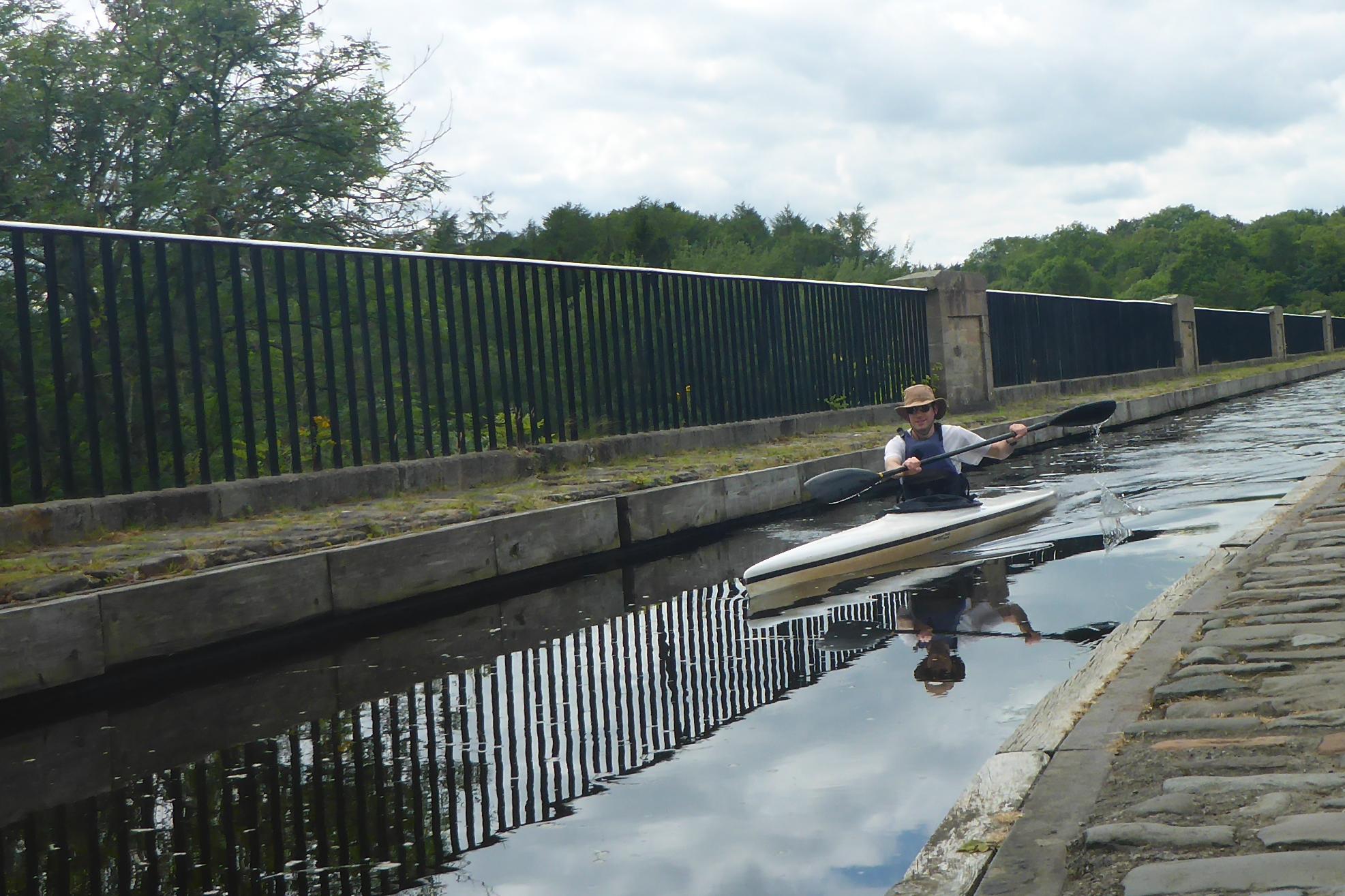 Person in a kayak with their paddle resting on the water